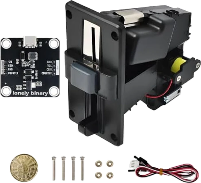 The kit laid out: the small square black module board with a USB-C socket and a four-pin header down each edge, the much larger black coin acceptor with its coin slot and reject flap, a gold-coloured token, four long machine screws, four nuts, and a four-way wiring harness with a white plug on one end.
