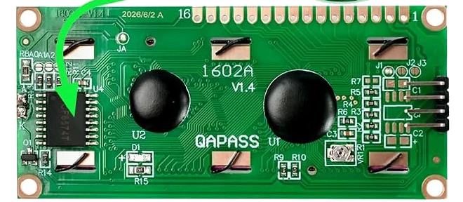 The back of the display: a green board printed 1602A V1.4 and QAPASS, two large black epoxy blobs covering the controller chips, a sixteen-pin small-outline chip on the left with three round solder pads printed A0 A1 A2 above it, and on the right a small silver trimmer and the four-pin header seen edge on.