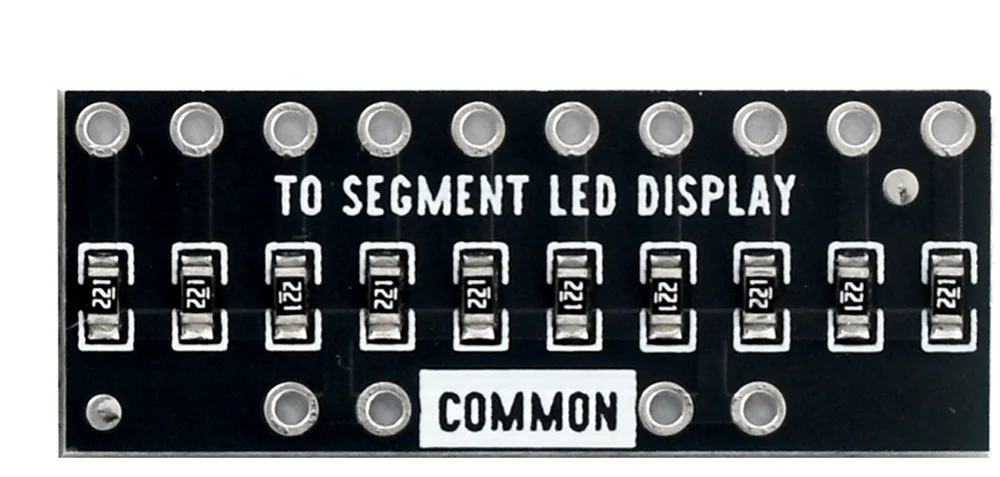 The front of the resistor array board: a row of ten plated holes above the words TO SEGMENT LED DISPLAY, ten small chip resistors marked 221 in a line beneath, and a lower row of four plated holes either side of a white label reading COMMON.
