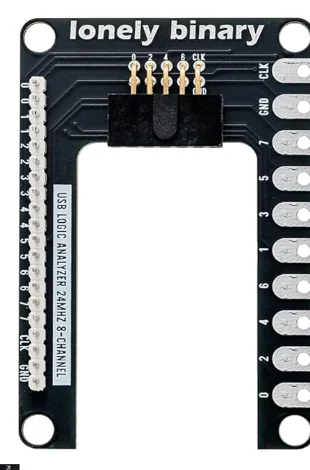 The expansion board: a black PCB with a 2x5 pin header in the middle labelled 0, 2, 4, 6, CLK along its top row, a strip of twenty plated holes down the left edge labelled in pairs 0 0 1 1 2 2 3 3 4 4 5 5 6 6 7 7 CLK CLK GND GND, and ten large oval pads down the right edge labelled CLK, GND, 7, 5, 3, 1, 6, 4, 2, 0. Silkscreen reads lonely binary and USB LOGIC ANALYZER 24MHZ 8-CHANNEL.