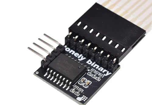 A soft keypad's ribbon tail with its black eight-way socket pushed onto the eight right-angle pins of a small black adapter board, the lonely binary logo and the PCF8574 chip visible, and the adapter's four pins sticking out to the left.