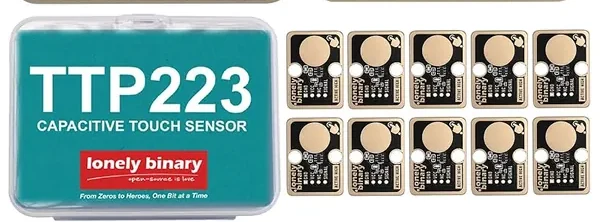 The 12-pack: a teal hinged storage case printed TTP223 CAPACITIVE TOUCH SENSOR with the lonely binary logo, beside two rows of five black touch sensor boards with gold-plated borders and a large gold circular touch pad on each.