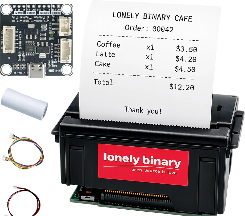 The receipt printer kit: a long black printer module with a receipt printed LONELY BINARY CAFE coming out of the top, the small square Type-C TTL base board above it, a paper roll, and two JST cables — one two-wire for power and one five-wire for serial.